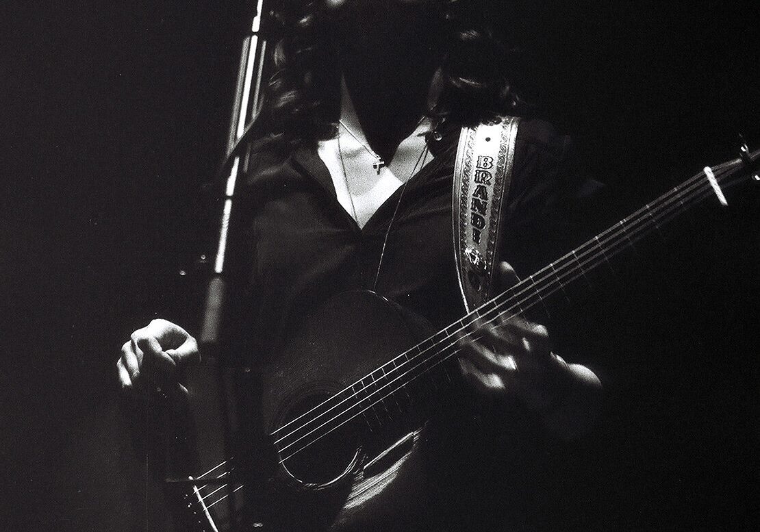 Musician passionately playing guitar on stage.