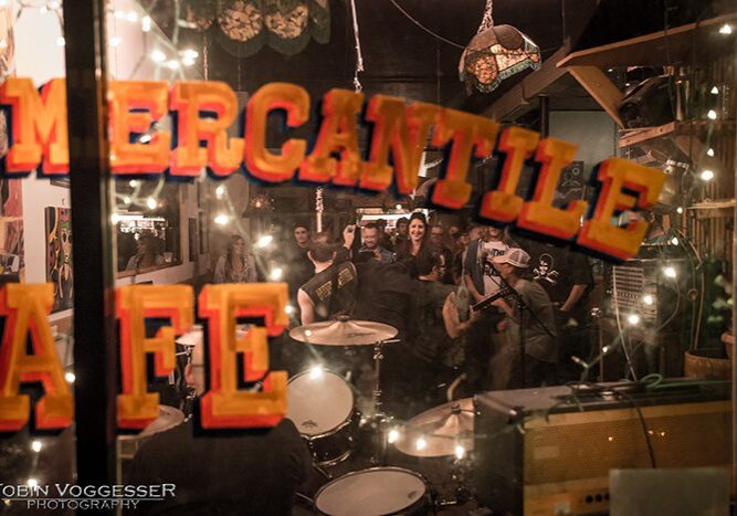 Band performing inside a lively cafe.