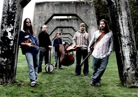 Band with instruments under concrete structure outdoors.