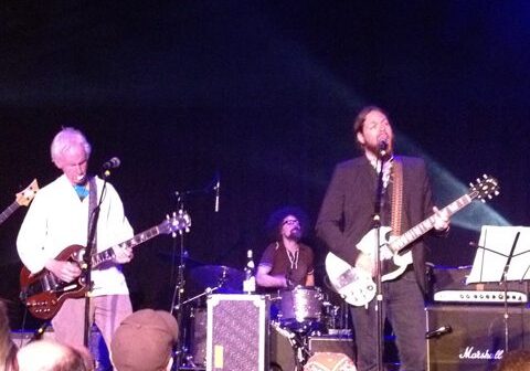 Band performing on stage with guitars.