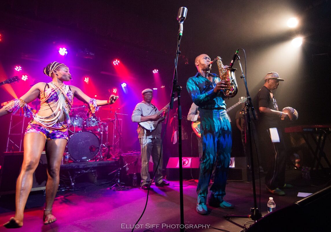 Live band performing on colorful stage.