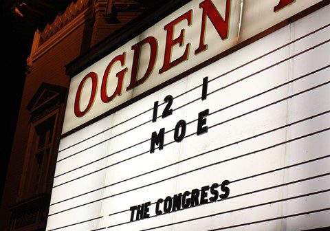 Theater marquee displaying event information at night.