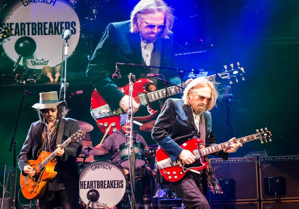 Musicians performing on stage with guitars.
