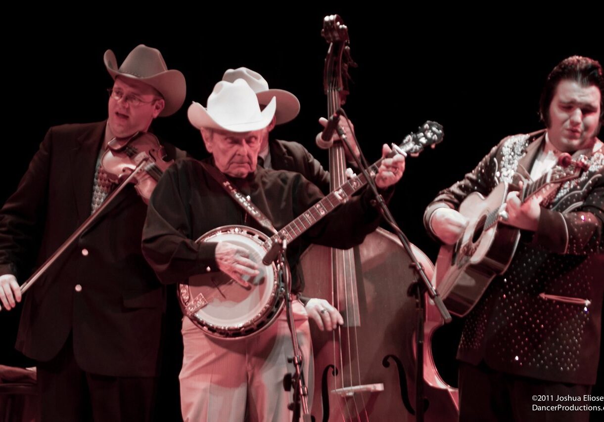 Country musicians performing with instruments on stage.