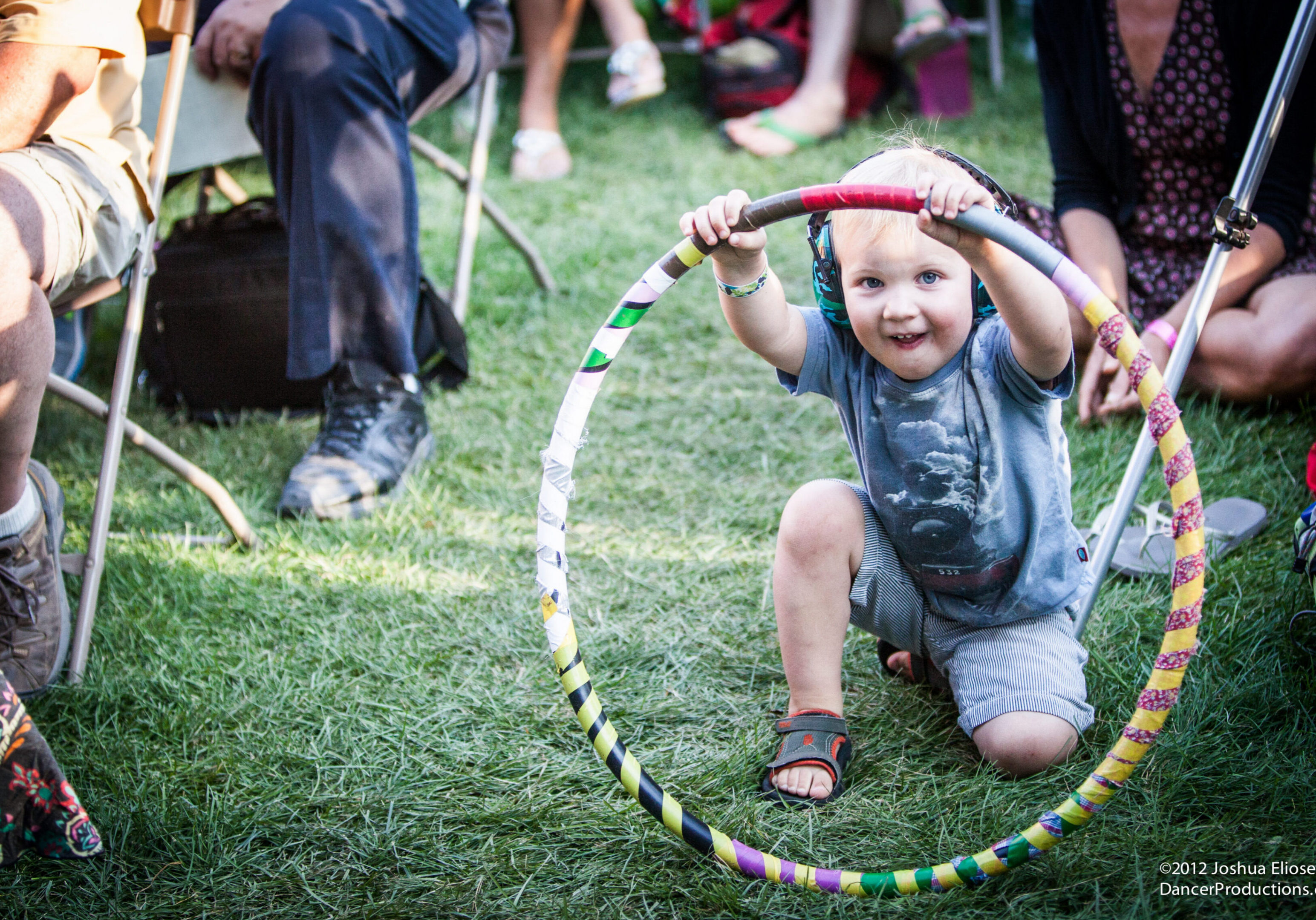 Child playing with a colorful hula hoop.