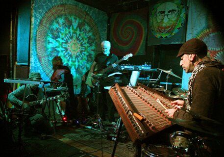 Musicians performing with colorful psychedelic backdrops.