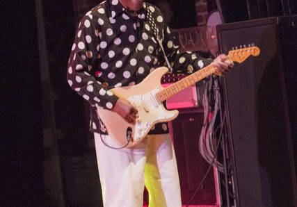 Man playing electric guitar on stage.