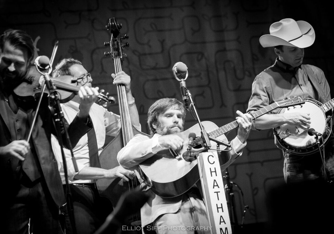 Band performing live with various instruments.
