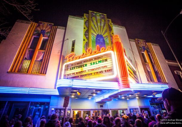 Colorful theater marquee with crowd outside at night.