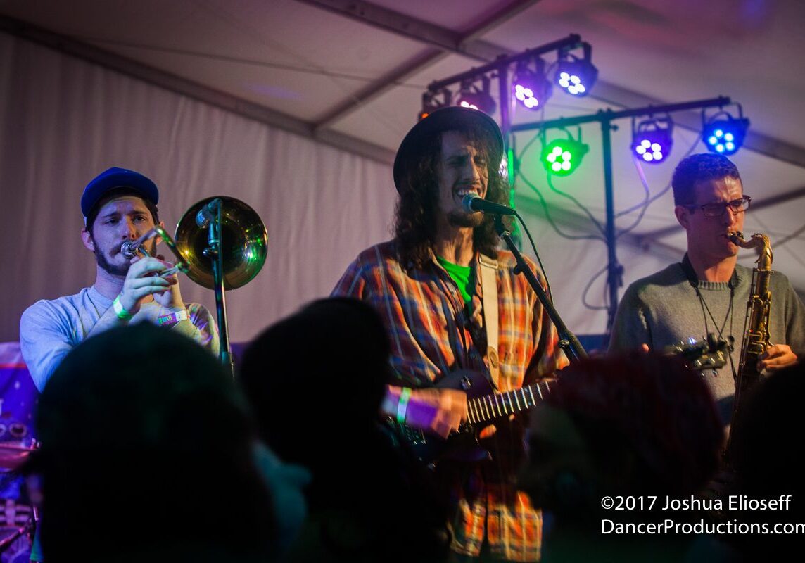 Band performing on stage with colorful lights.