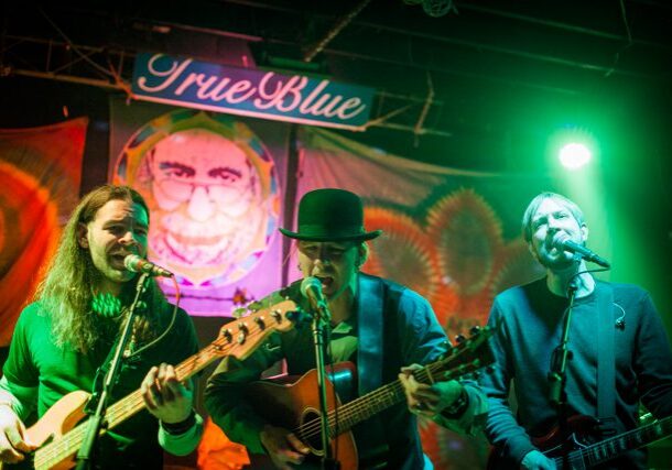 Band performing live on colorful stage.