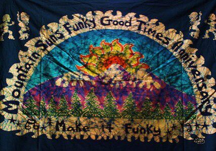 Tie-dye tapestry with sun and trees.