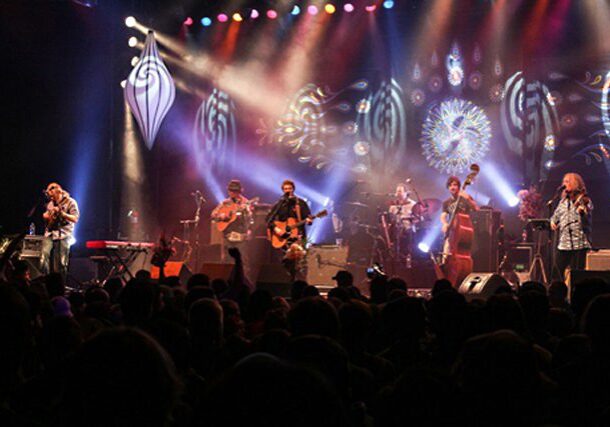 Band performing on stage with colorful lights.