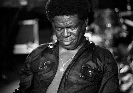 Singer performing passionately on stage, black-and-white.