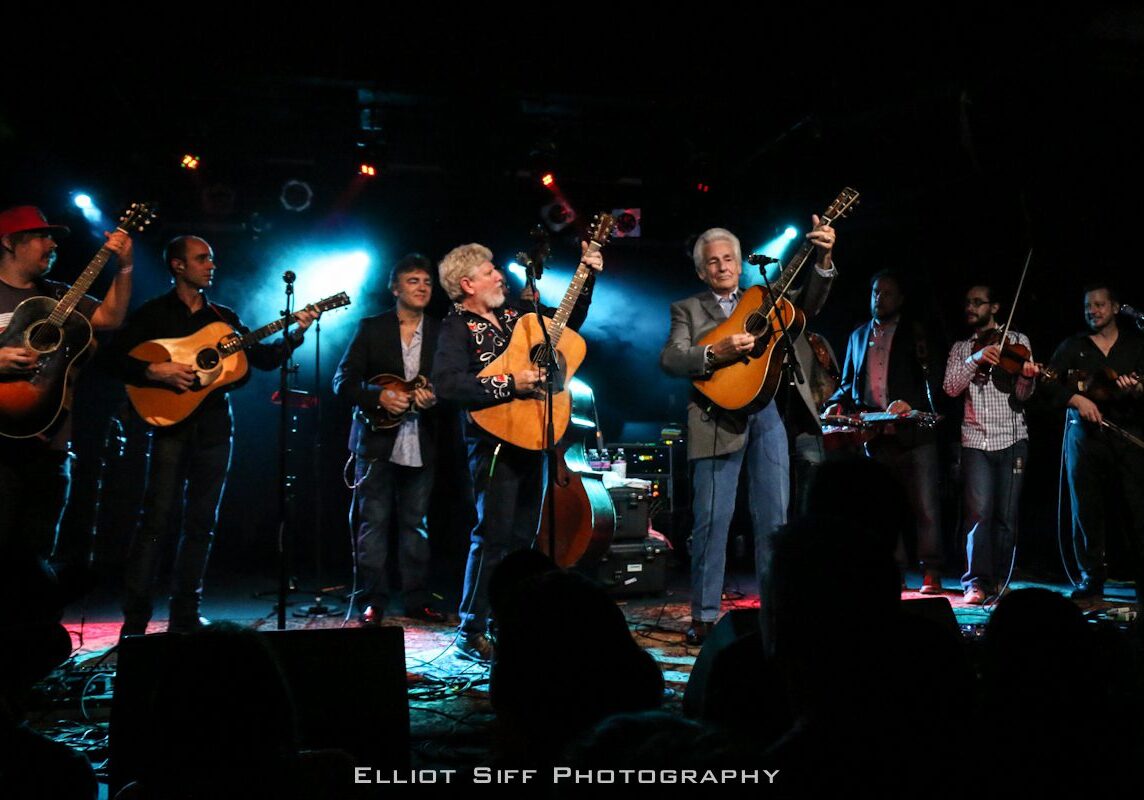Band performing live on stage with guitars.