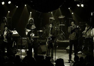 Band performing on stage with instruments.