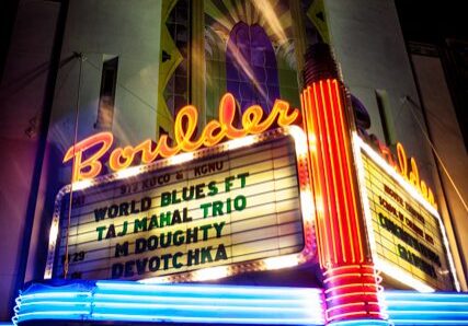 Neon-lit Boulder theater marquee at night.