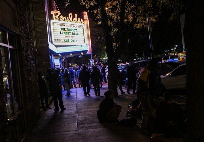 People outside Boulder theater at night.