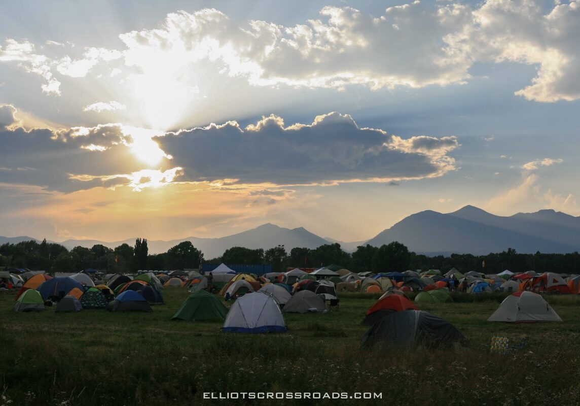 Tents in a field at sunset.