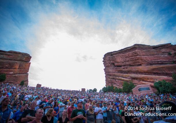 Crowd gathered at outdoor amphitheater under sky.