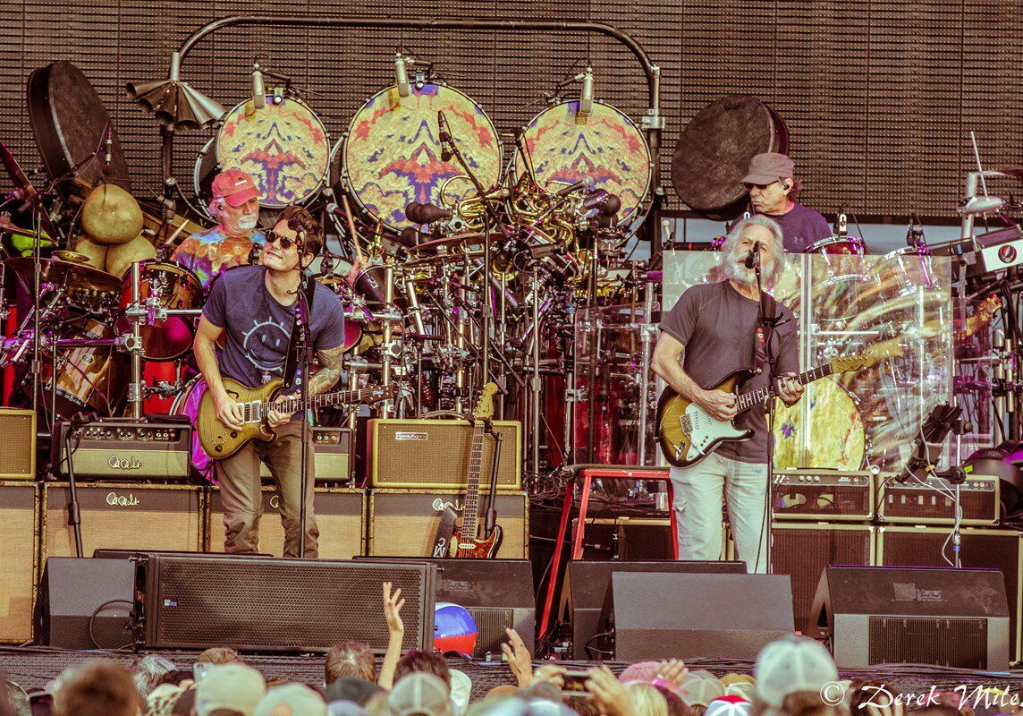 Band performing live on stage with guitars.