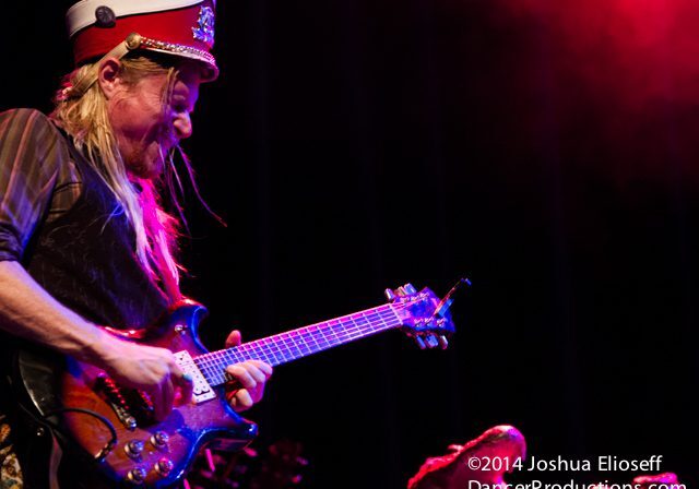 Guitarist performing energetically on stage.