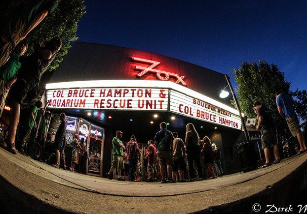 People gathering outside a theater at night.