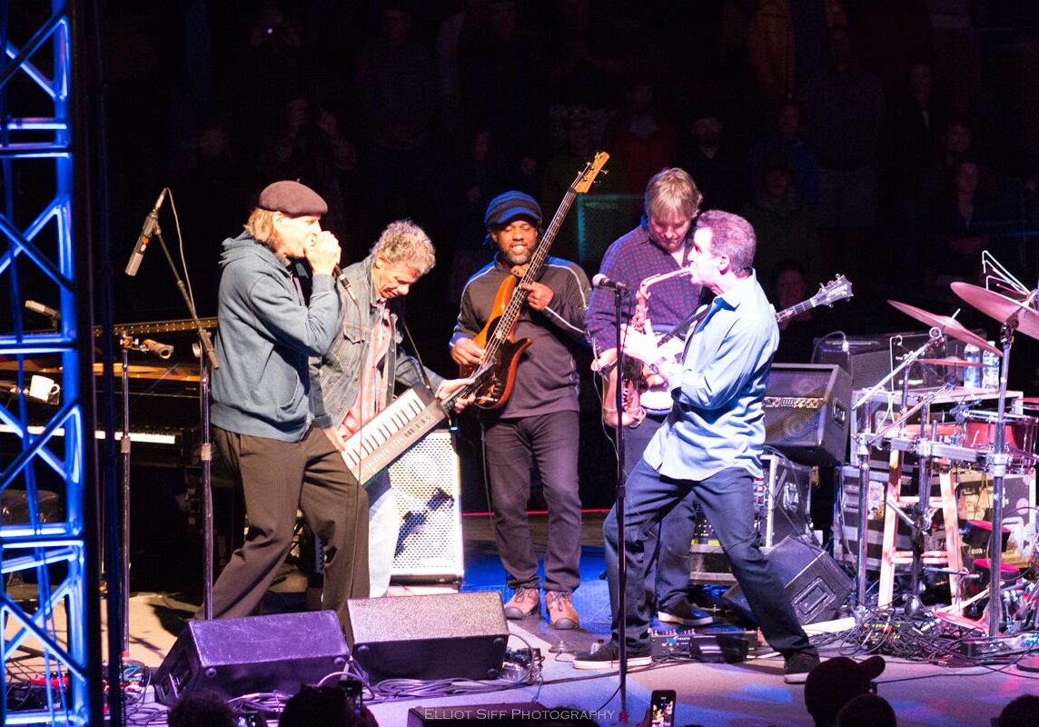 Live band performing on stage with instruments.