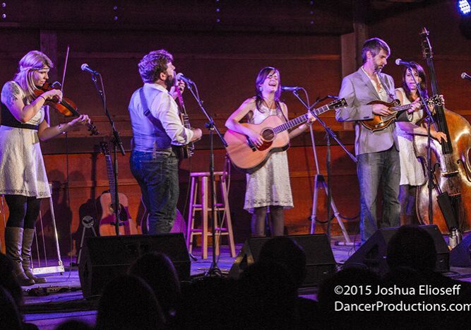 Band performing on stage with musical instruments.