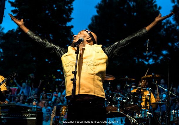 Singer performing energetically on outdoor stage.