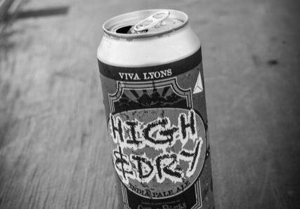 Beer can on wooden table, black-and-white.