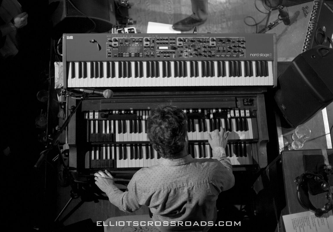 Musician playing keyboards on stage, overhead view.