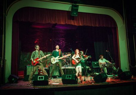 Band performing on stage with instruments.