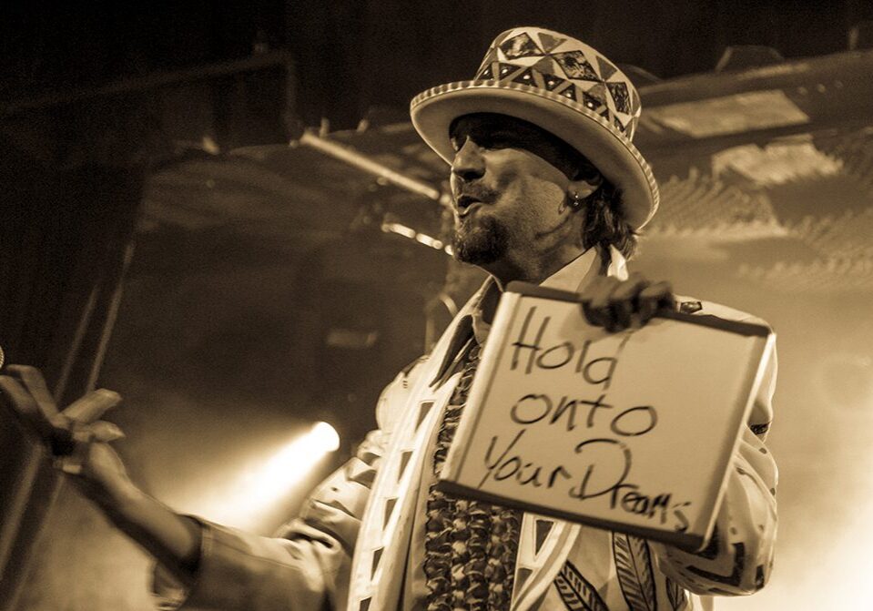 Performer holding sign with motivational message.