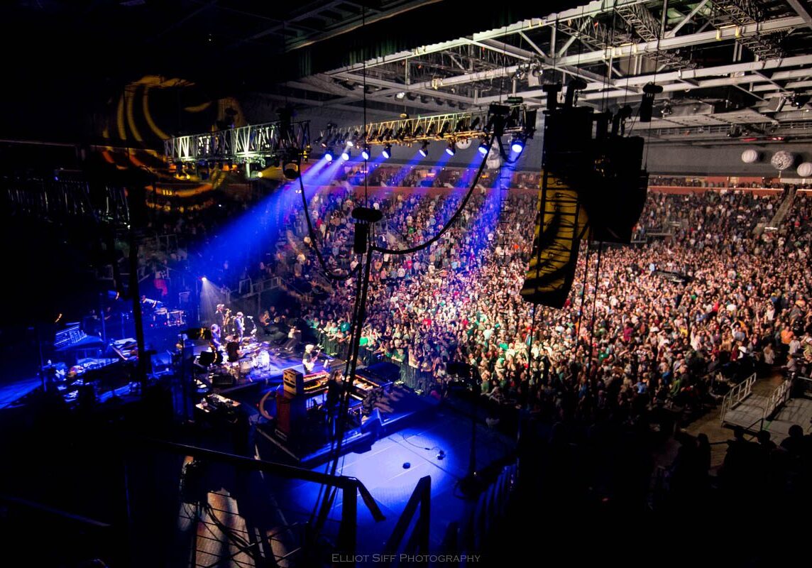 Concert crowd with colorful stage lighting.
