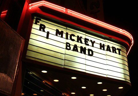 Theater marquee displaying band name at night.