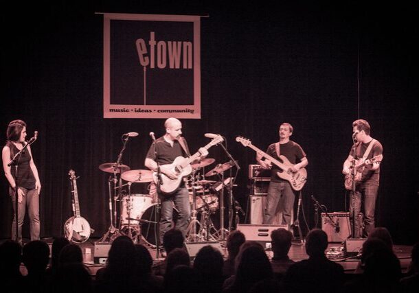 Band performing on stage at eTown concert.