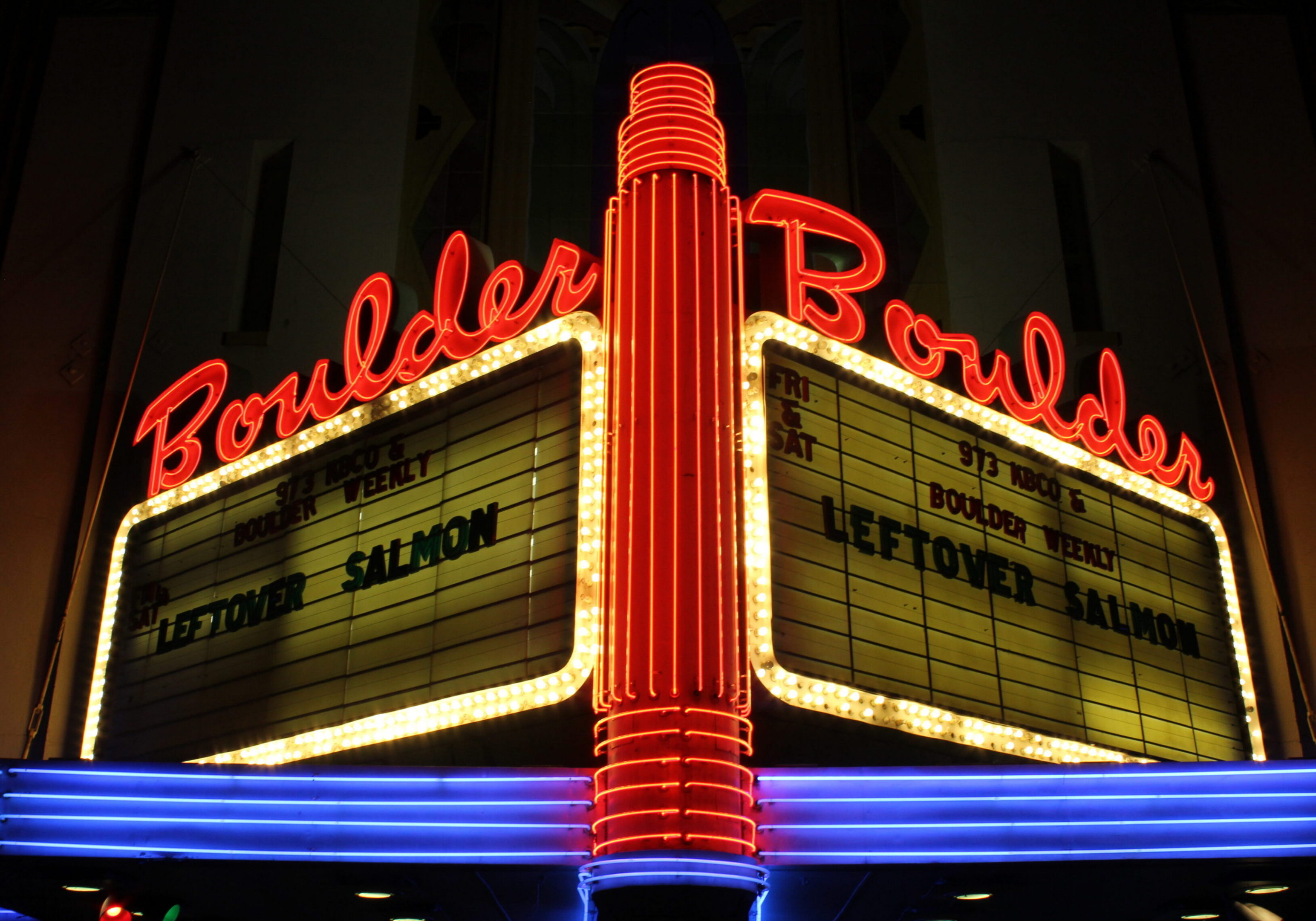 Neon-lit Boulder theater marquee at night.