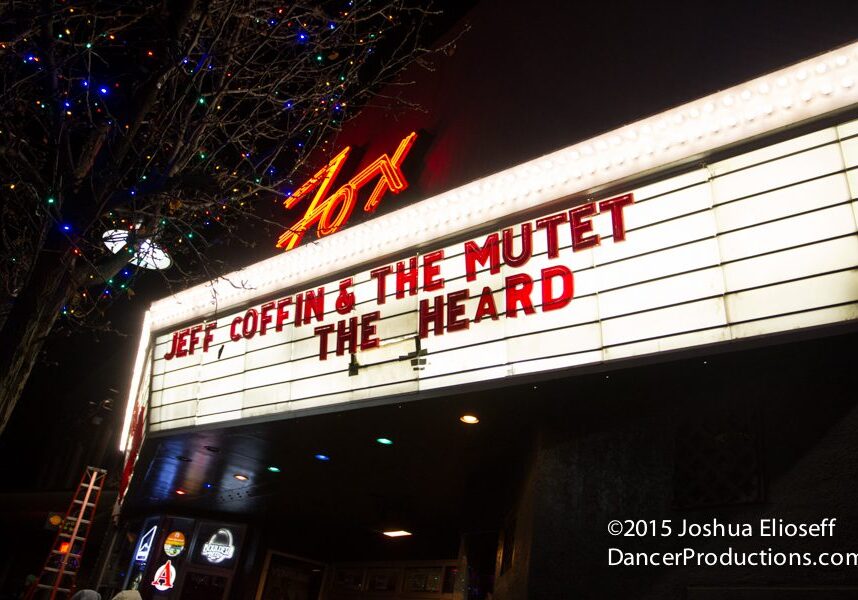 Concert marquee at night with colorful lights.