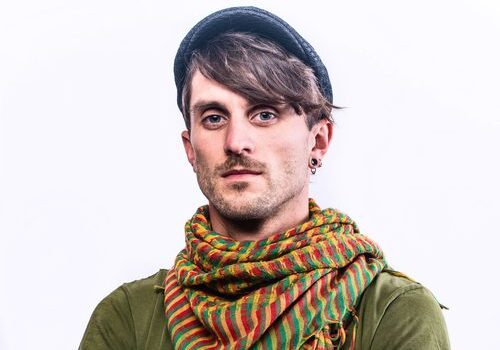 Man wearing hat and colorful striped scarf.