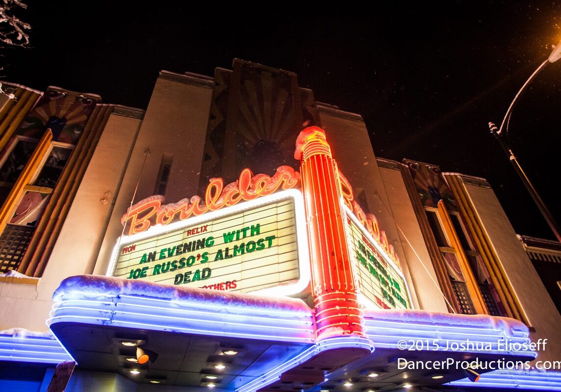 Historic theater marquee with neon lights at night.