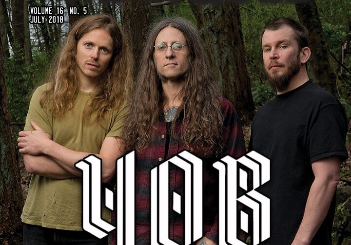 Band members on magazine cover in forest.