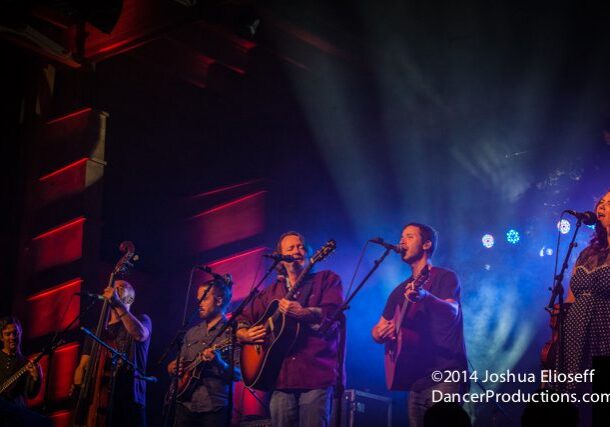 Band performing on stage with instruments.