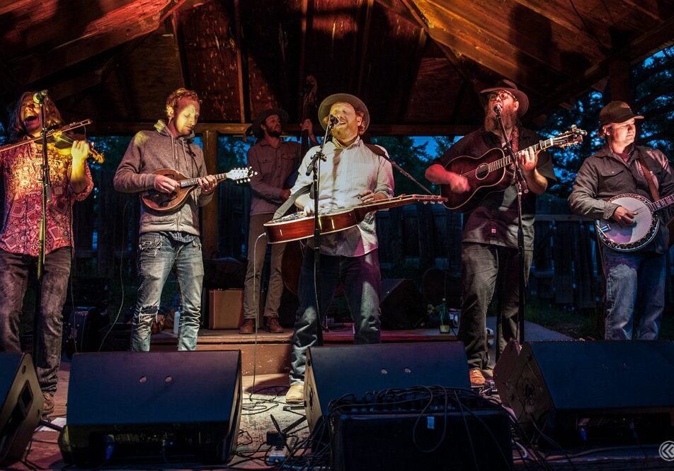 Band performing on outdoor stage at night.