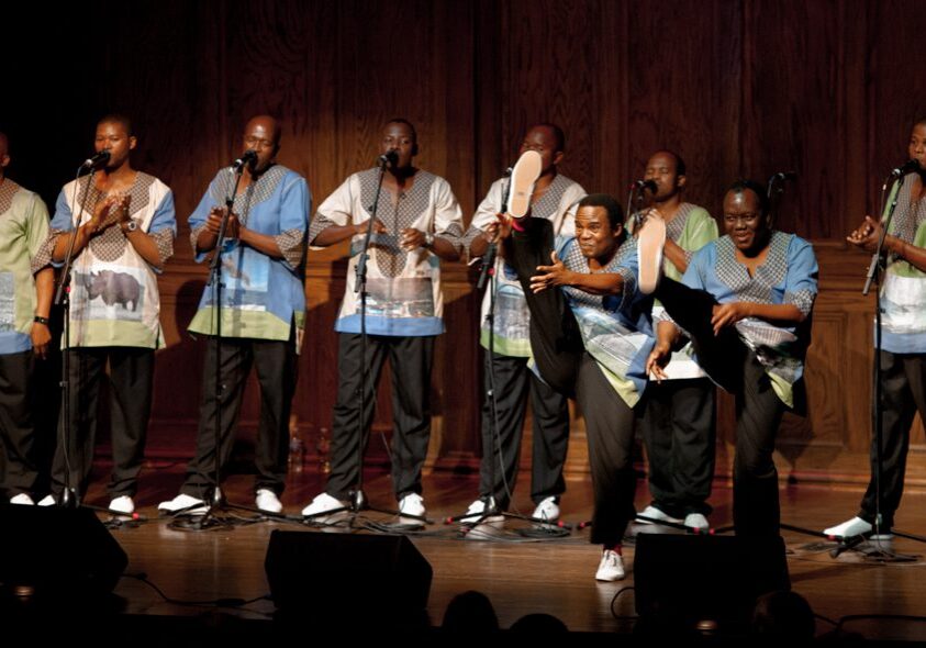 Singers performing on stage with microphones.