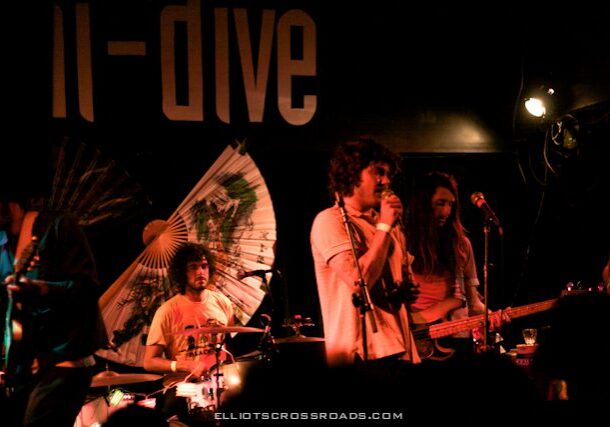 Band performing live on dimly lit stage.