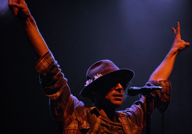 Singer on stage with raised arms.