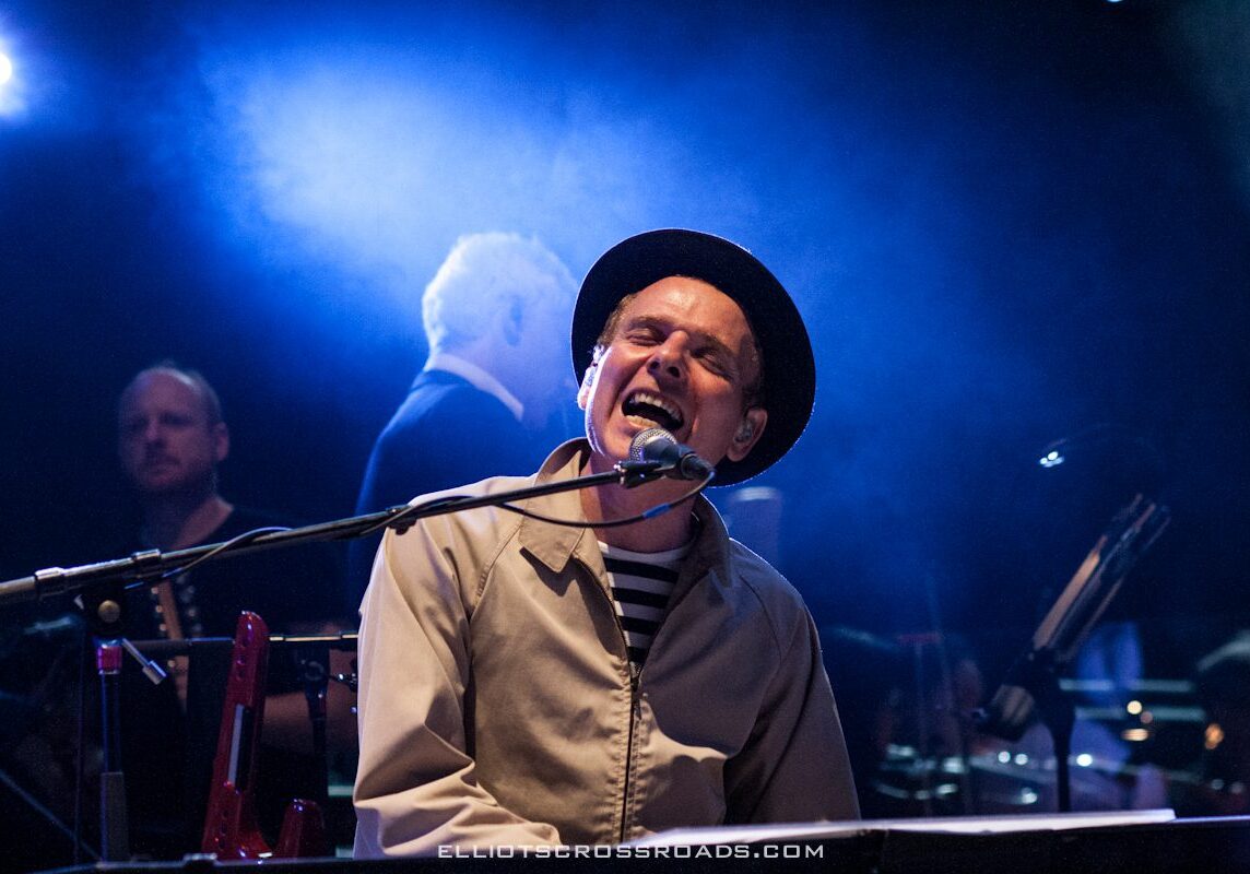 Musician passionately singing and playing keyboard.