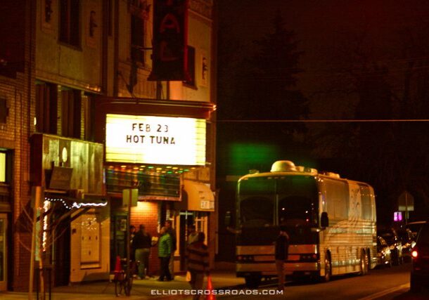 Marquee sign and tour bus at night.