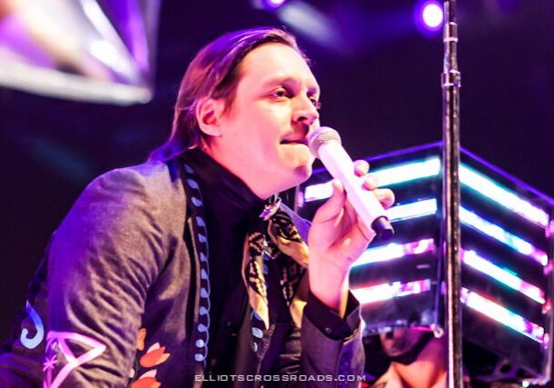 Singer performing on stage with microphone.